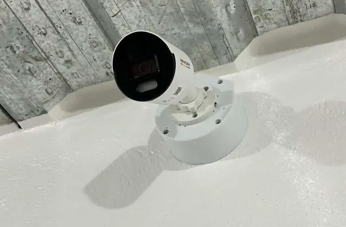 A Hikvision CCTV camera mounted in a ceiling corner, part of a client's security installation.