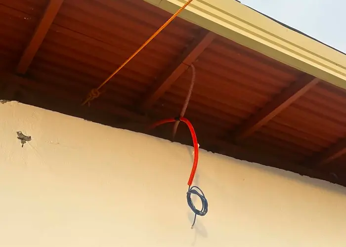 Conduit and cabling roughed in under a roof eave before the exterior finish is completed.