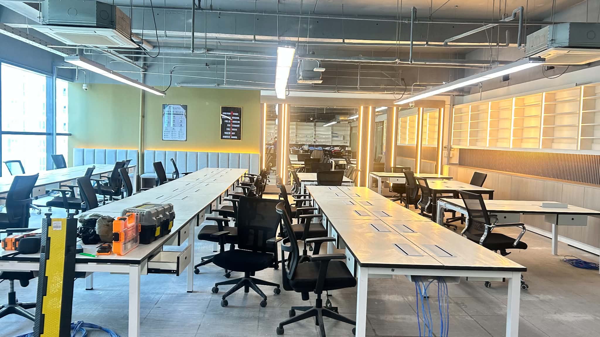 Everyday Pharmacy new office workspace in Cebu New Town with desks, lighting, ceiling routes, and installation tools visible.