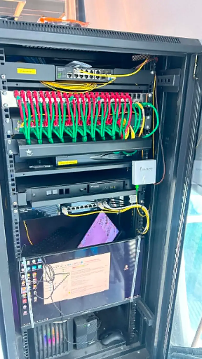Completed server rack with color-coded green and red patch cables neatly dressed and organized.