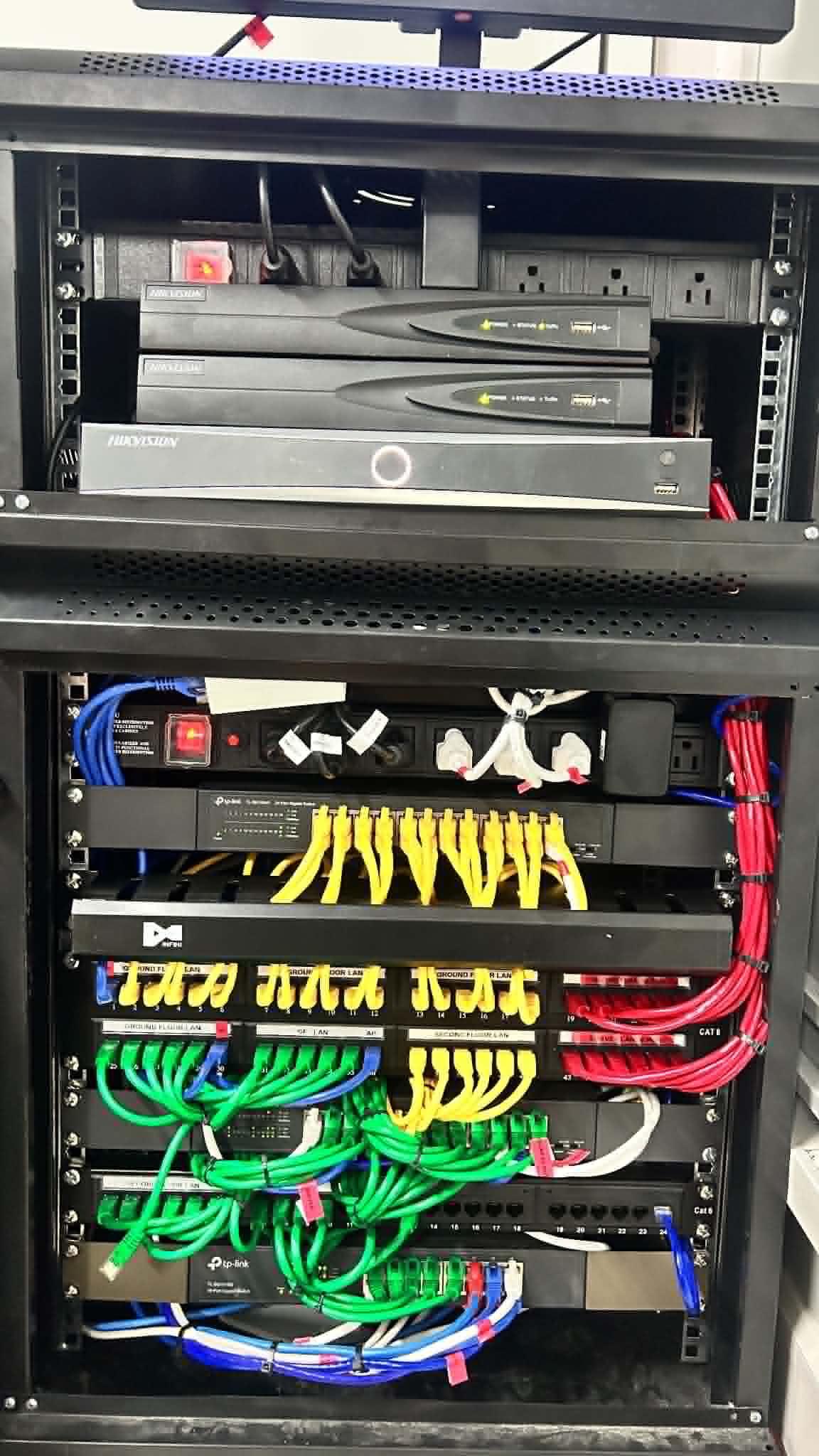 Full server rack with organized patch panels, switches, and color-coded cabling for business infrastructure.