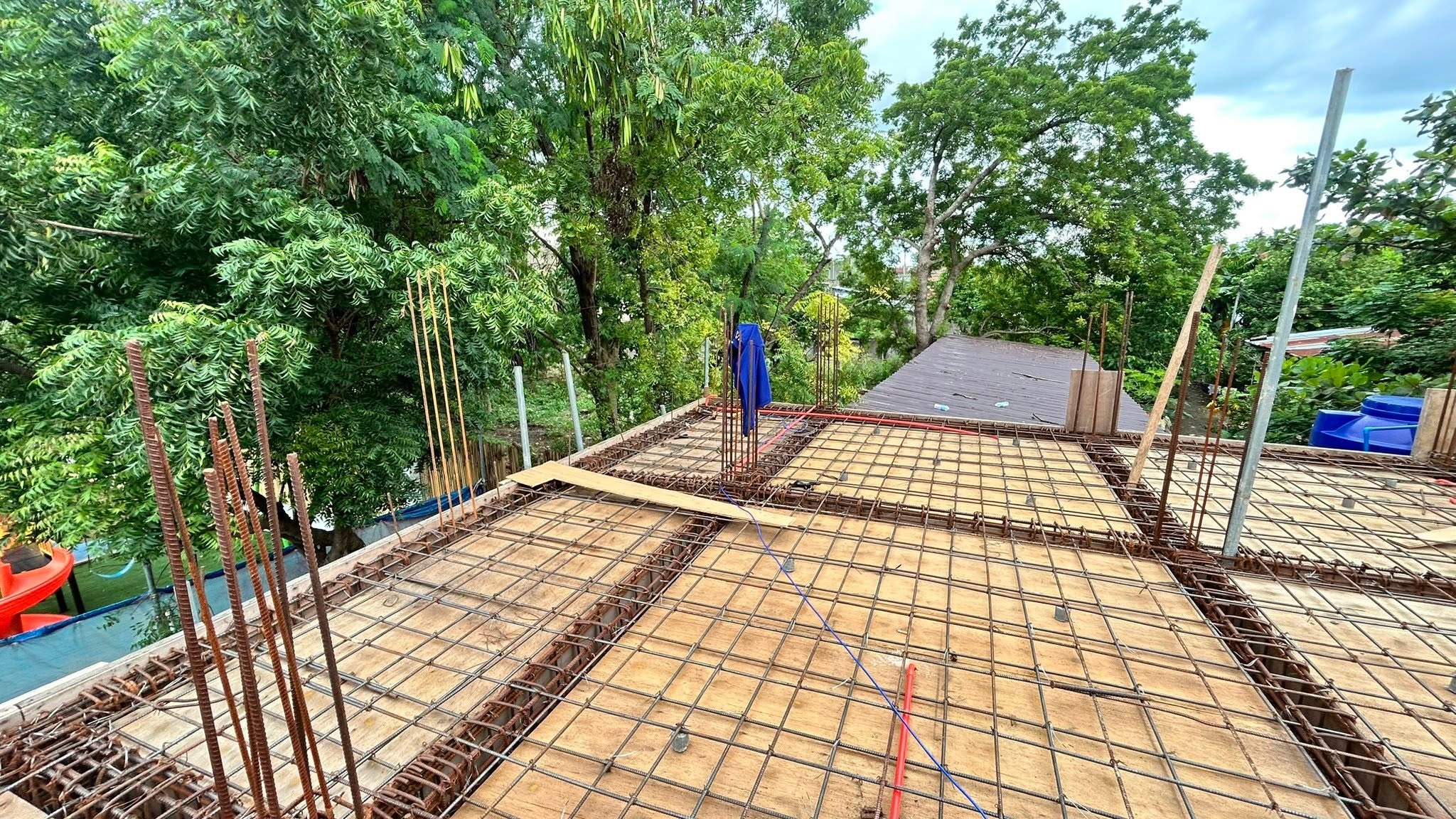 Steel rebar mesh and conduit routed across a residential roof deck under construction, before the concrete pour.