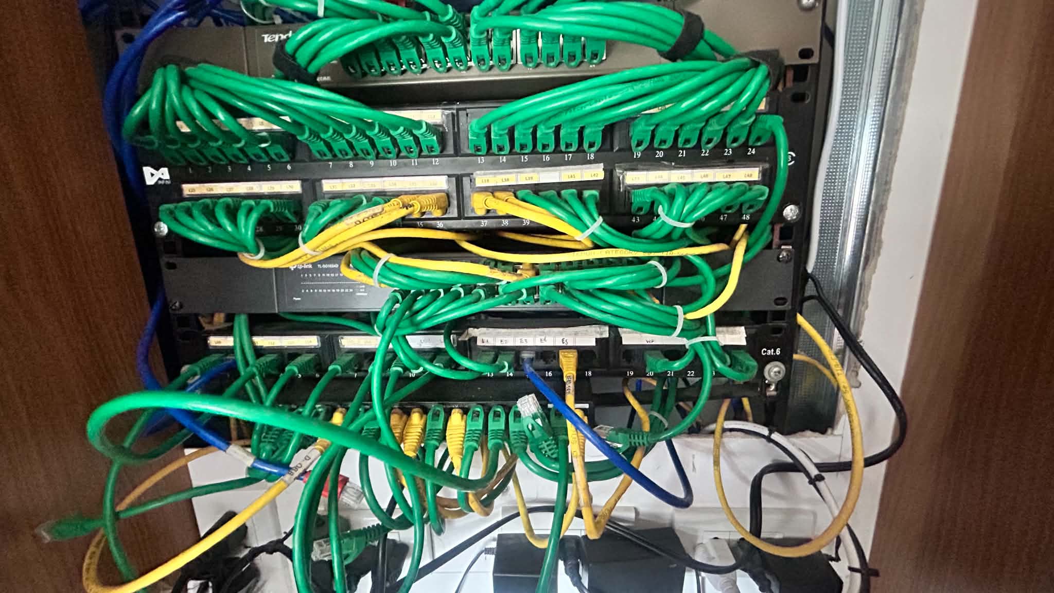 Network rack with multiple patch panels, labeled runs, and active switch connections for the warehouse office setup.