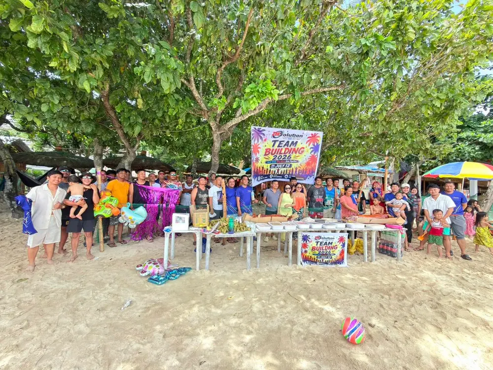 The whole JM Solution team gathered on the beach in San Remigio under the Team Building 2026 banner.